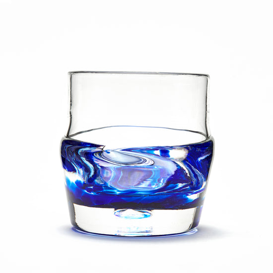 Hand blown glass whiskey glass, clear with a swirl of cobalt blue glass on the bottom.