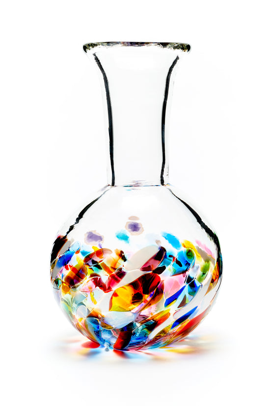 Hand blown glass vase. Purple, blue, yellow, red, orange, green, and white glass on the bottom. Colour combination is called "Multi."